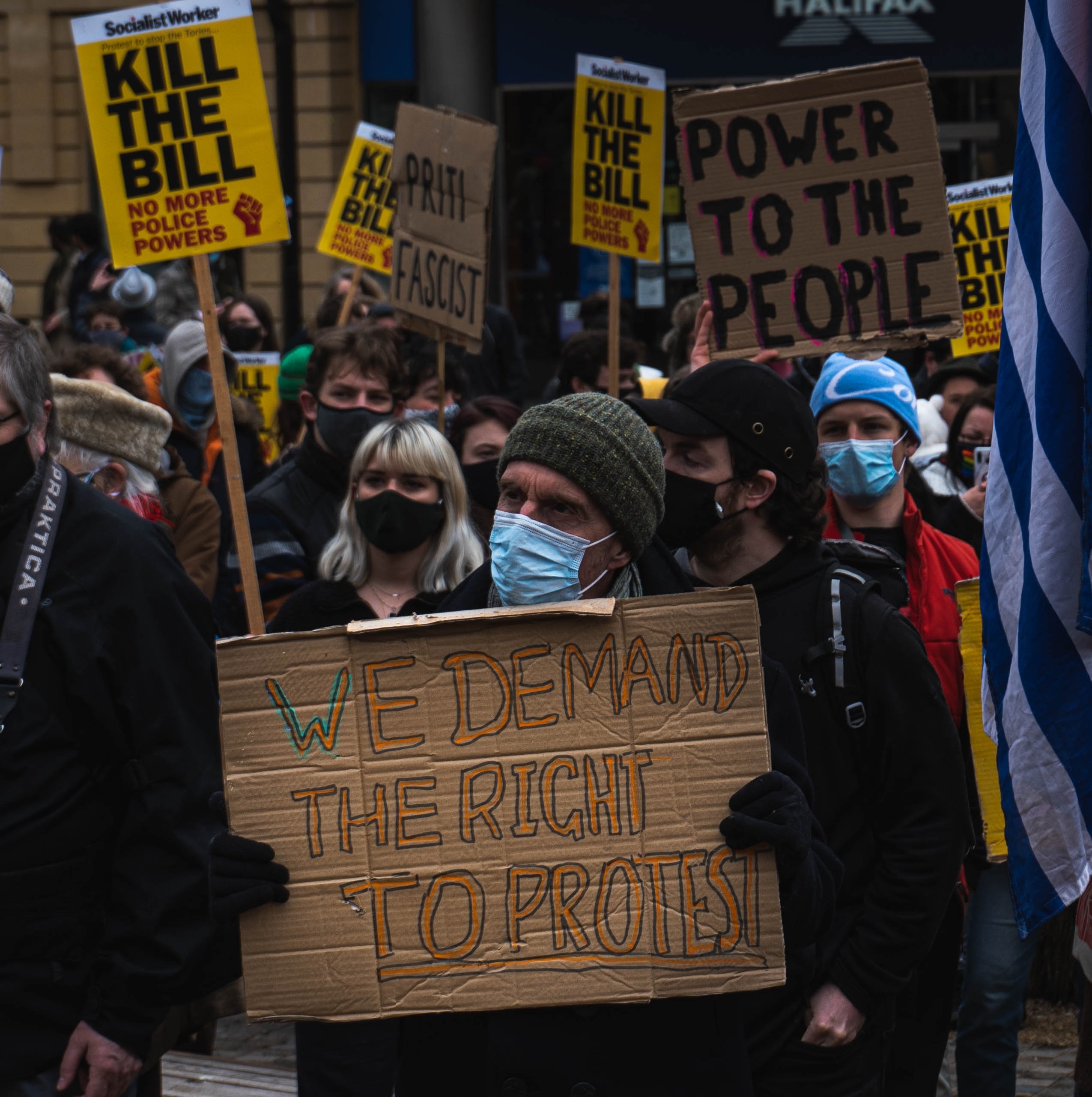 a crowd that are protesting in the UK hold signs with the right to protest on
