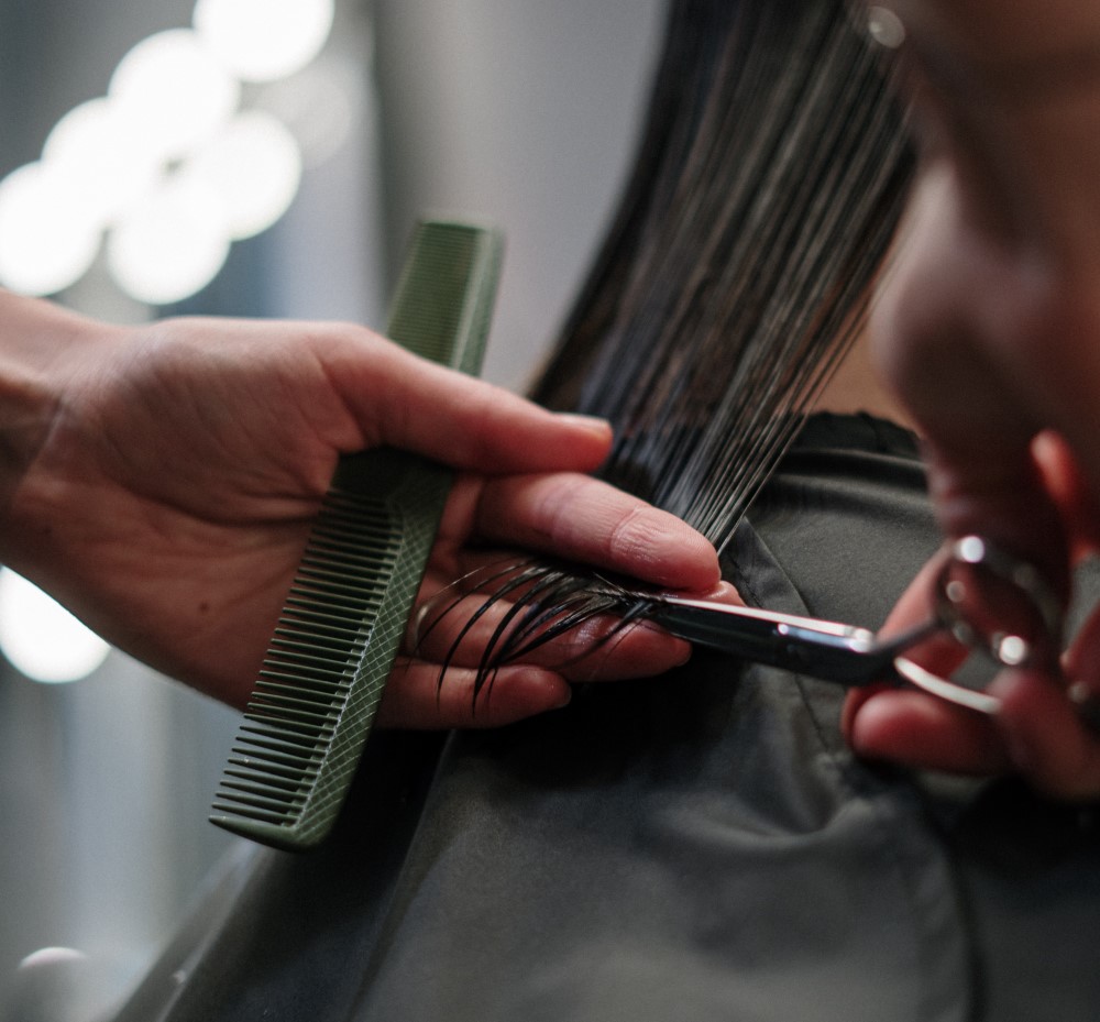 a hairdresser cuts a women's hair 