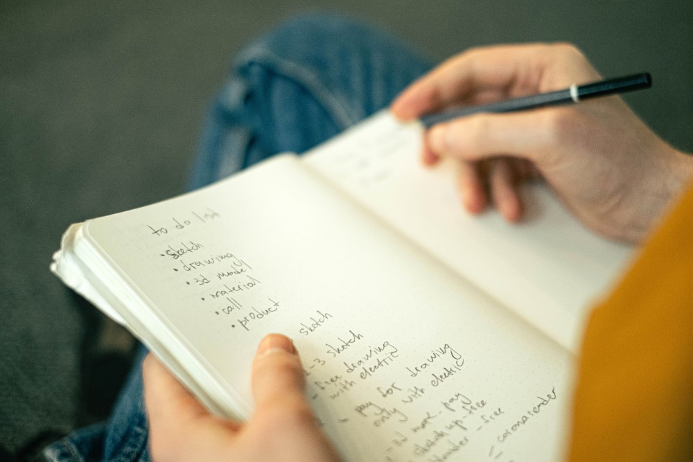 a man notes down his productivity list working from home 