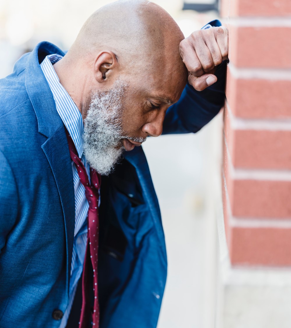 an employer looks stressed outside after unfairly dismissing