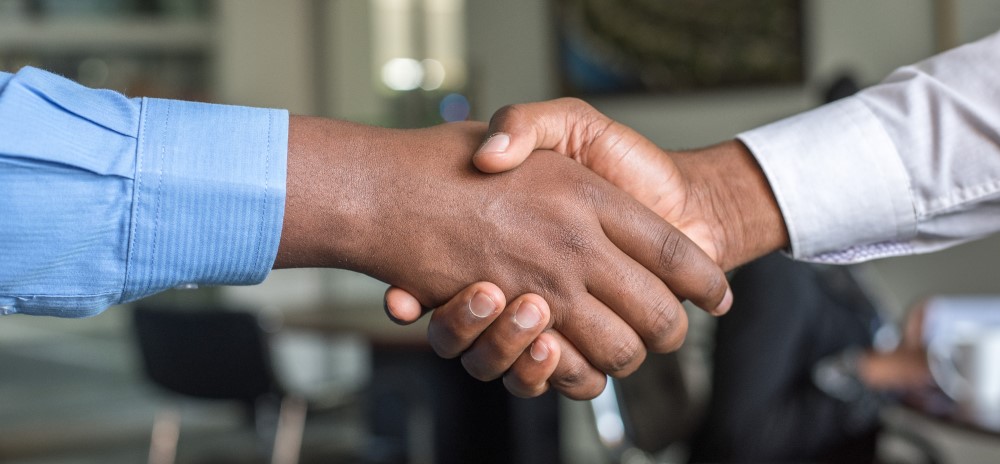 an employer and employee shake hands after a settlement agreement