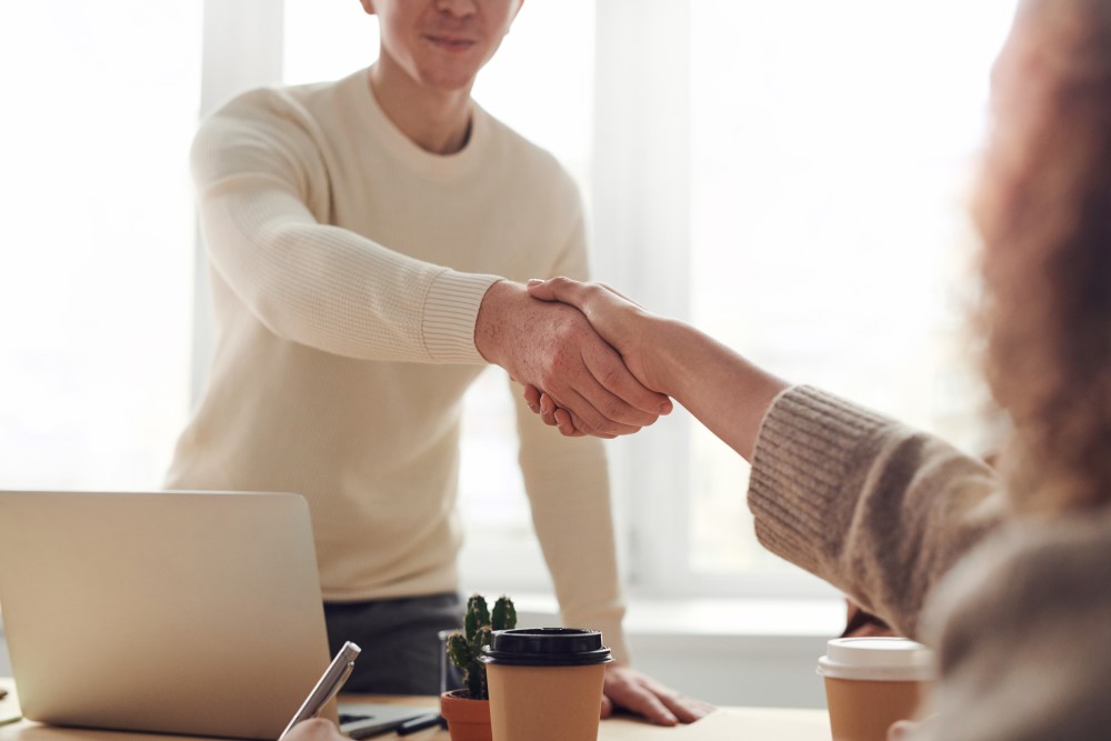 an employer shakes hands with a Acas advisor