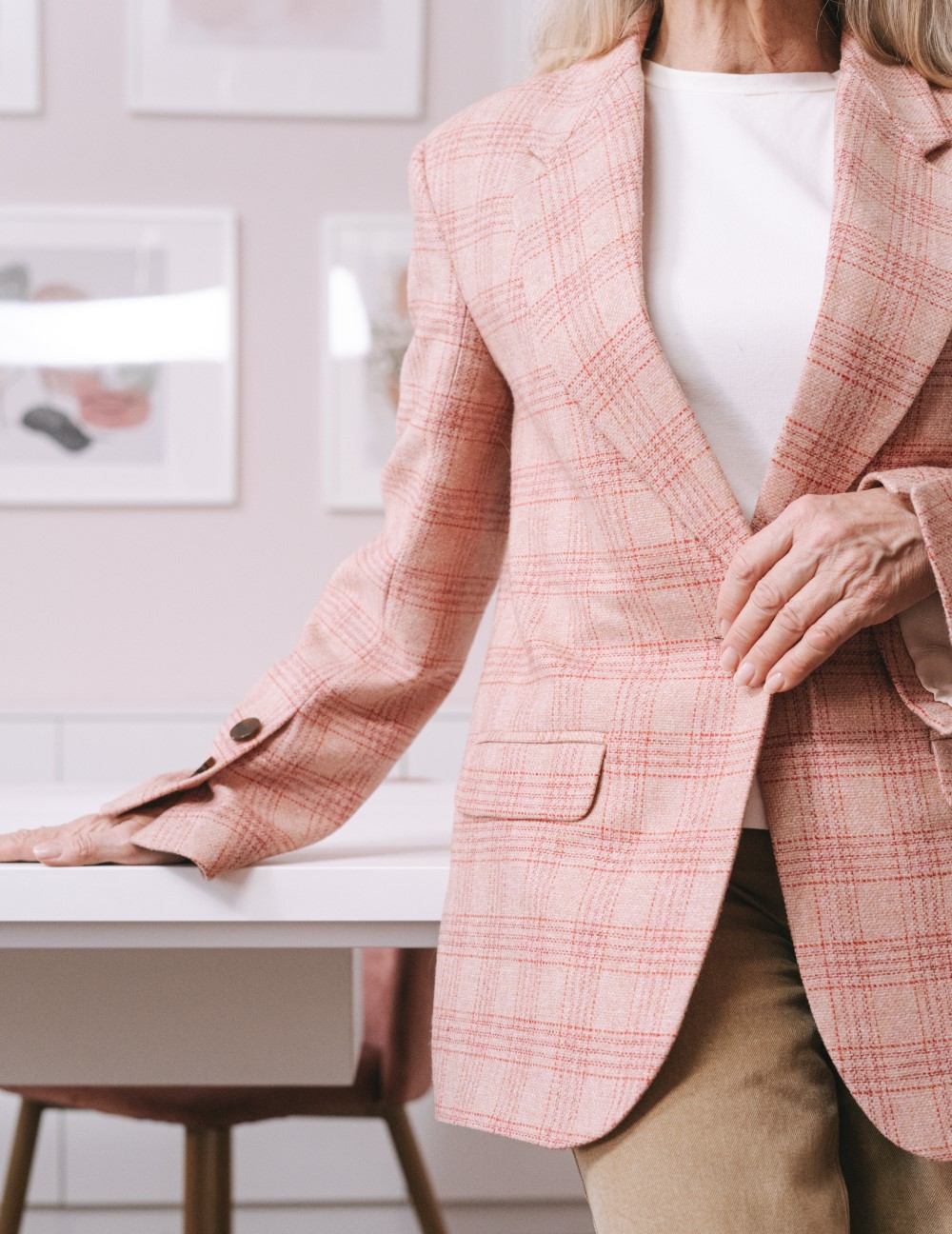a women business owner stands in a pink suite