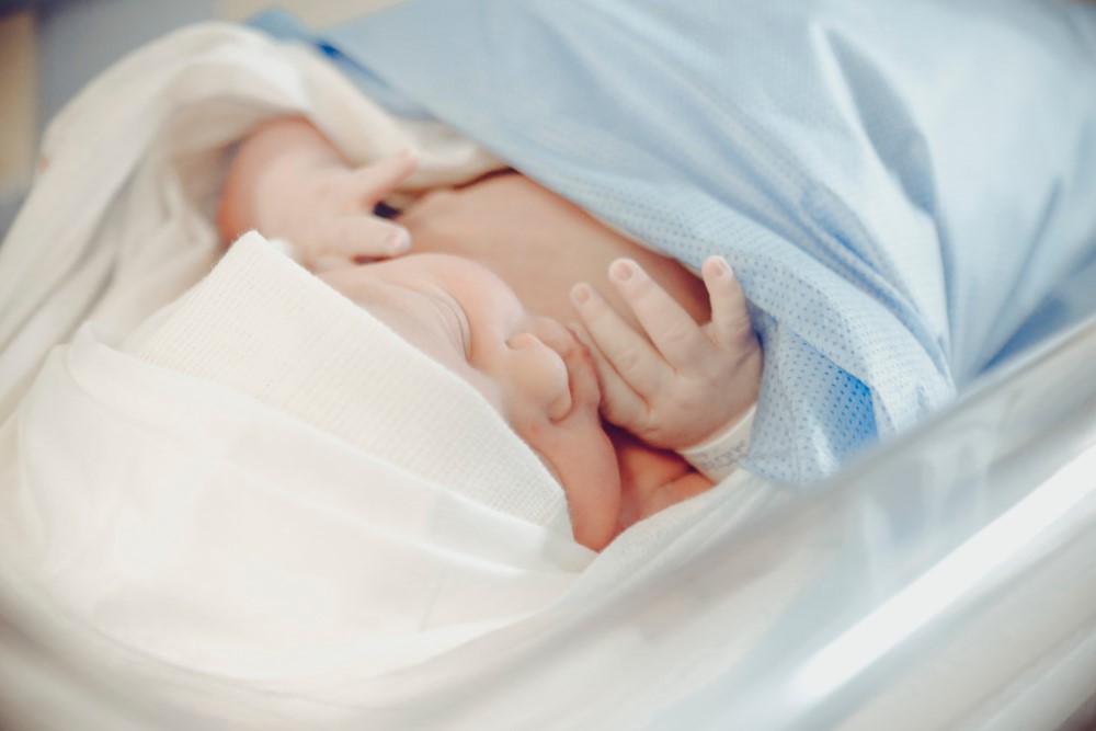 a baby sleeps inside an incubator in hospital