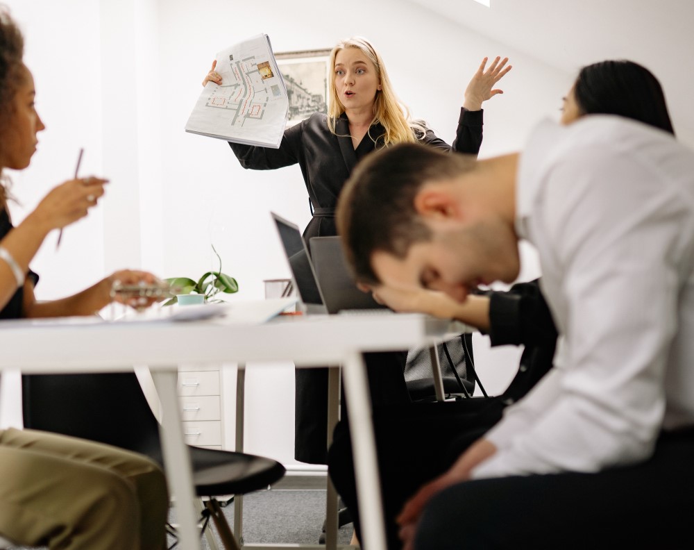 a manger shouts at their employees in the office