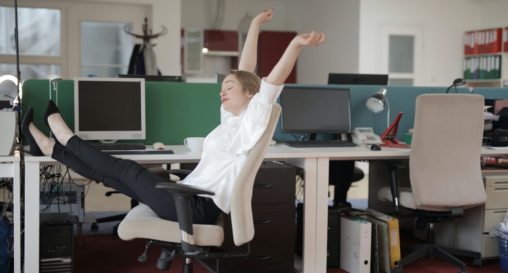 a women put her feet up in the office on top of a desk